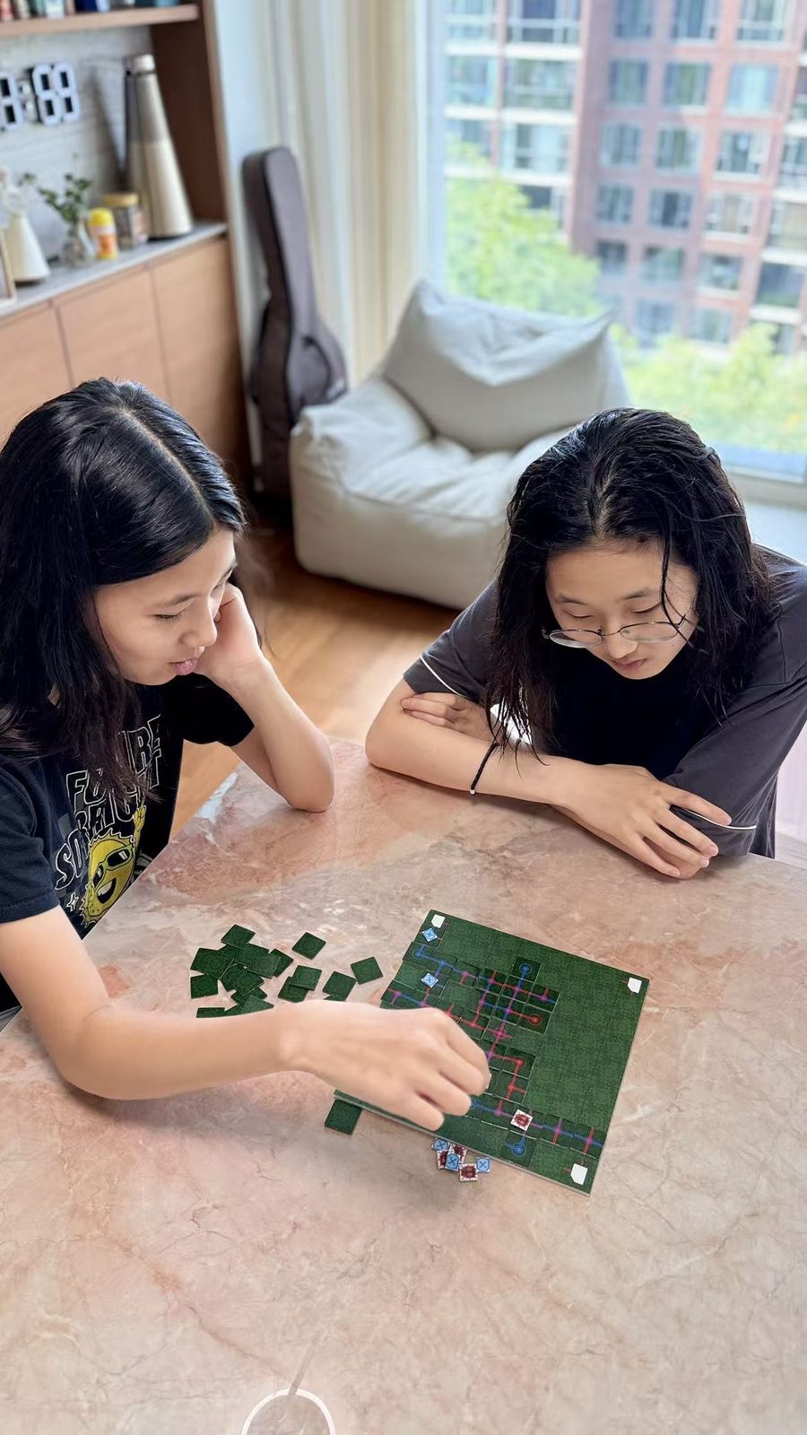 Two people playing the board game at a marble table